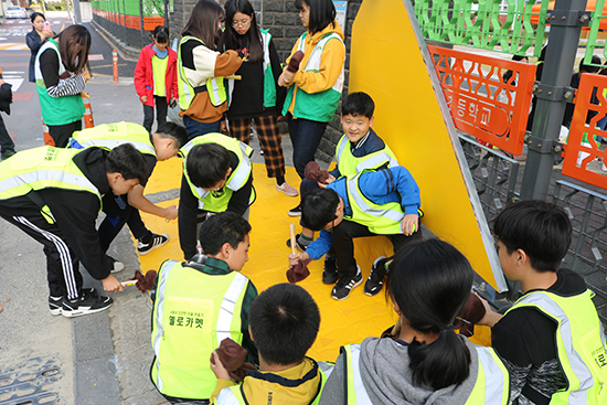 한천초 옐로카펫 설치식에서 아이들이 직접 옐로카펫을 설치하고 있는 모습.