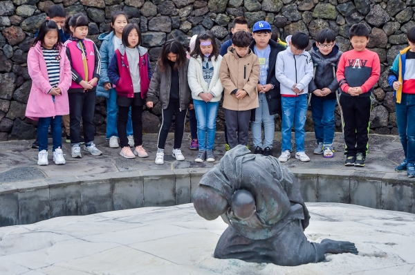 4·3평화공원을 찾은 어린이들이 눈 더미 속에서 발견된 모녀의 넋을 기리는 ‘비설’ 조형물 앞에서 묵념을 하고 있다.