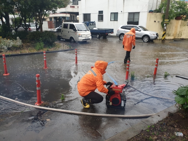 제주시 도남동의 한 도로가 쏟아지는 빗물에 침수돼 119대원들이 배수 작업을 벌였다.