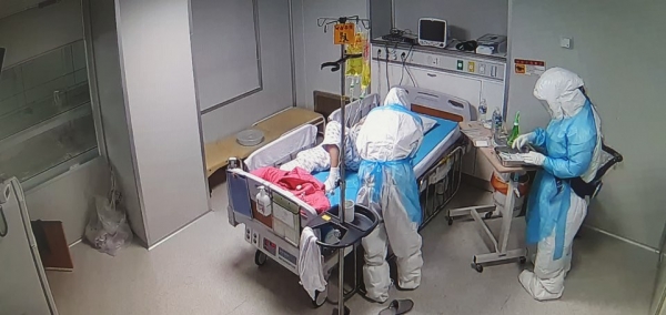 의료진들이 전신 방호복을 입고 환자를 치료하고 있다.