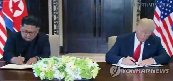 역사적 첫 북미정상회담이 열린 12일 오전 싱가포르 센토사 섬 카펠라호텔에서 미국 도널드 트럼프 대통령과 북한 김정은 국무위원장이 합의문에 서명하고 있다.