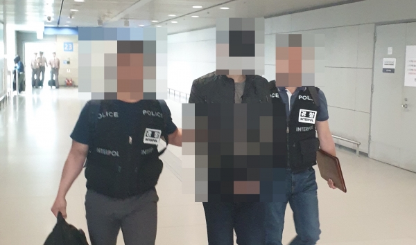 경찰 수사를 피해 일본으로 도주했다 국제공조수사 끝에 검거된 불법 음란사이트 운영자 고모씨(34)가 인천국제공항에서 경찰에 연행되고 있다.