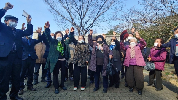 4.3행방불명 희생자 故 오형률씨의 아내 현경아씨(101세·사진 왼쪽에서 네 번째) 등 유족들이 21일 제주지법 정문 앞에서 만세를 외치고 있다.